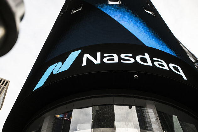 Информационная панель биржи NASDAQ на первых этажах небоскрёба Конде-Наст-билдинг на Таймс-сквер в Нью-Йорке
