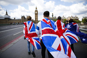!Люди с флагами Великобритании на Вестминстерском мосту в Лондоне