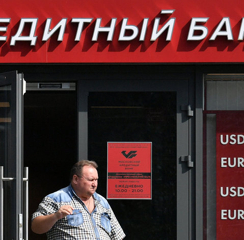 Мужчина выходит из отделения "Московского кредитного банка". 16 августа 2017