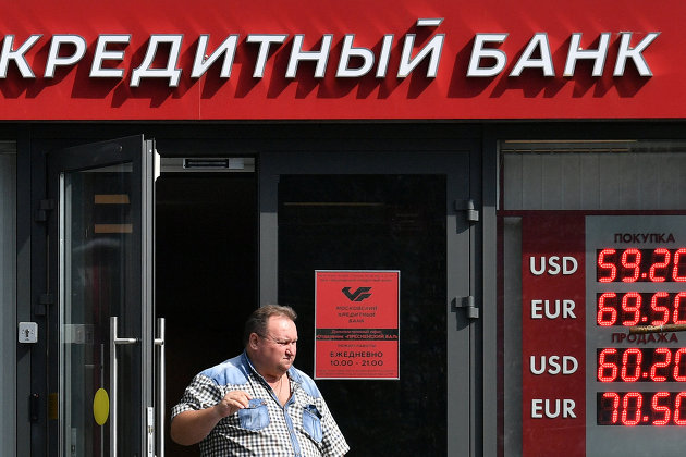 Мужчина выходит из отделения "Московского кредитного банка". 16 августа 2017