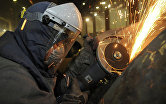 Рабочий во время обработки изделий на сталелитейном производстве.
