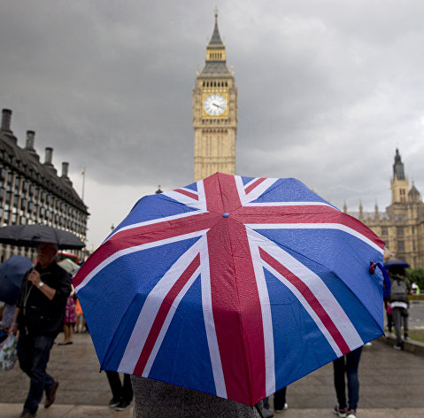" Человек с зонтом с флагом Великобритании у Биг Бена и здания парламента в Лондоне