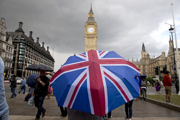 " Человек с зонтом с флагом Великобритании у Биг Бена и здания парламента в Лондоне