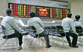 Инвесторы смотрят на электронное табло в Корейской фондовой бирже в Сеуле, Южная Корея