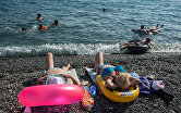Отдыхающие на пляже около Олимпийского парка в Сочи