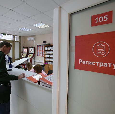 Посетитель у регистрационного стола в поликлинике №180 в Москве