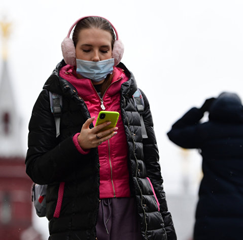 Девушка в маске со смартфоном