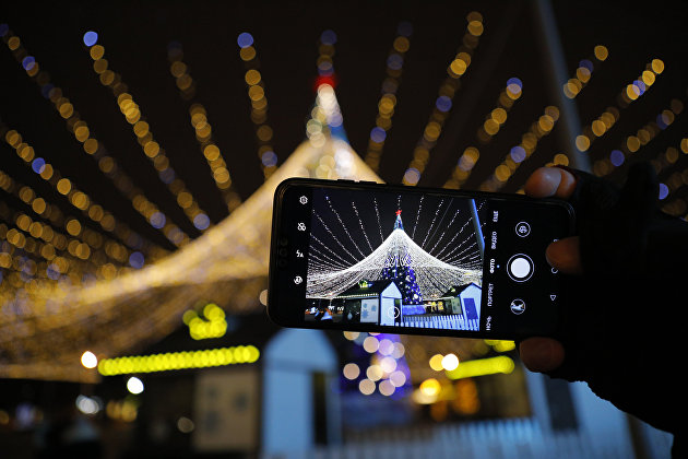 Экран смартфона с изображением новогодней елки