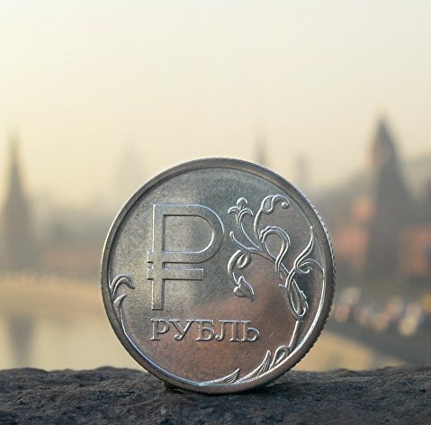 Рублевая монета на фоне Московского Кремля