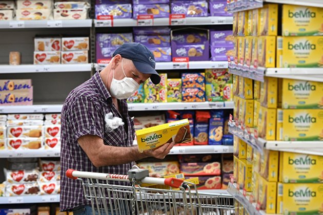 Покупатель выбирает товар в бакалейном отделе гипермаркета "Ашан" в Москве
