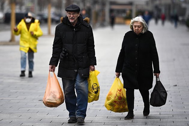 Мужчина с женщиной идут с покупками на Новом Арбате в Москве