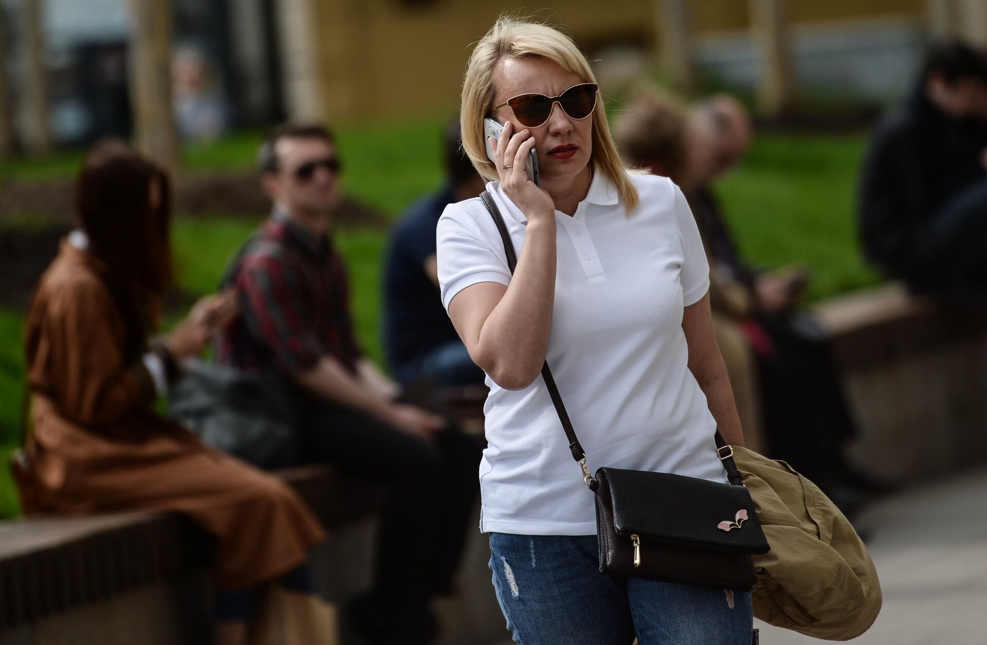 Женщина говорит по телефону на улице Москвы - ПРАЙМ, 1920, 16.06.2022